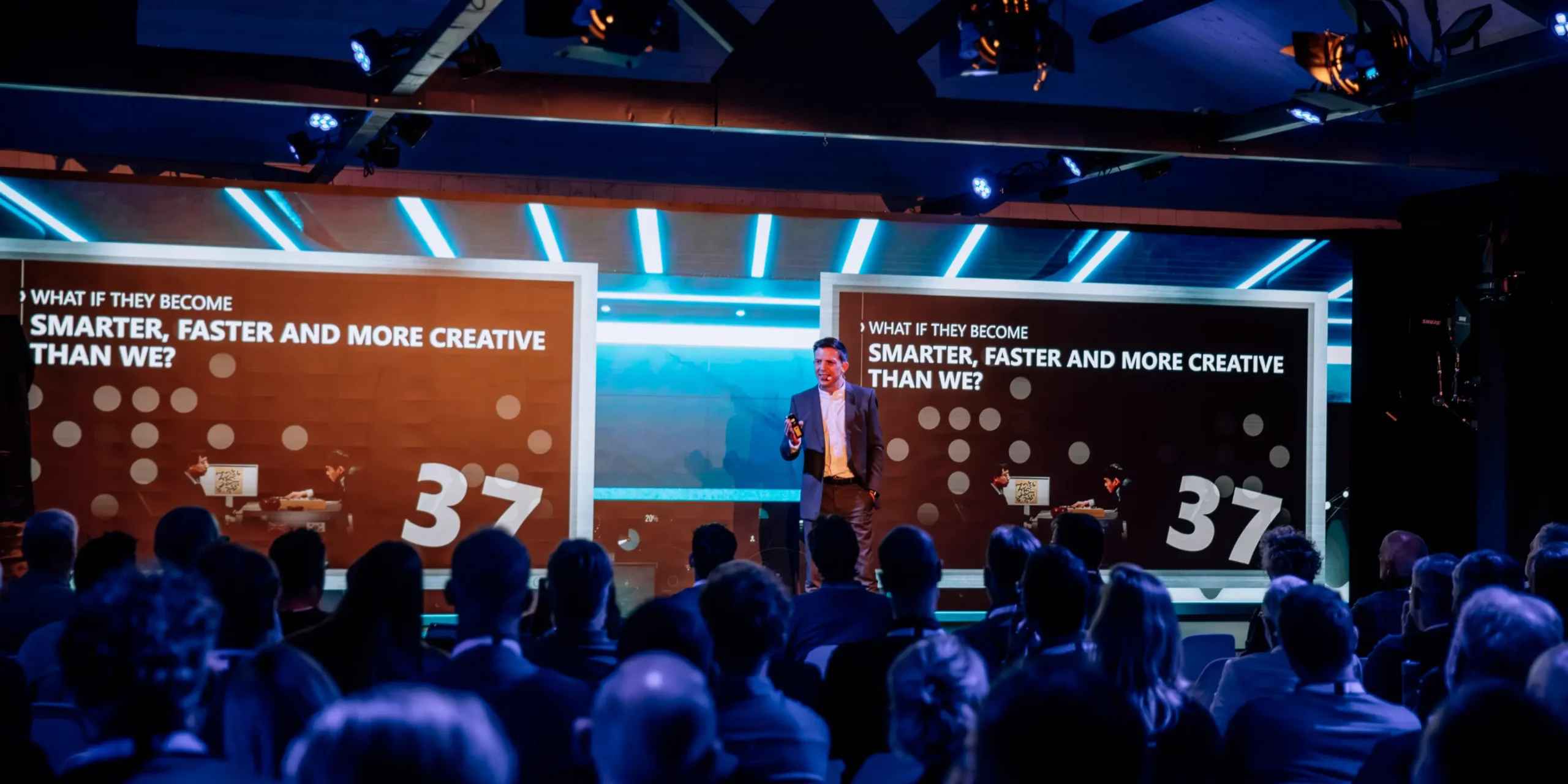 Raumbeduftung-event-konferenz-praesentation | zaluti b. V. Ein redner hält eine präsentation vor aufmerksamem publikum im beachclub degreez; raumbeduftung schafft eine subtile atmosphäre für die konferenz.