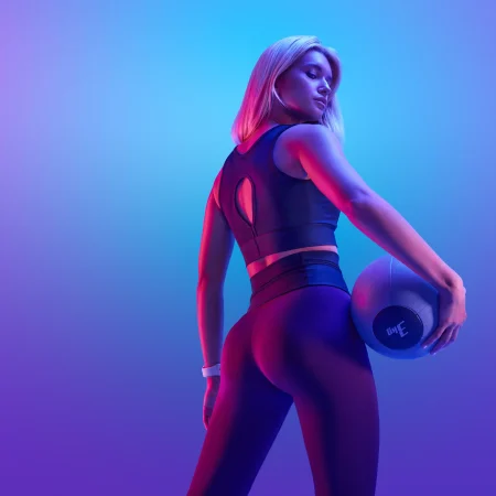 Vrouw met fitness bal met neon style achtergrond