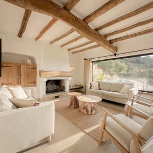Bright living room with wooden beams, natural light, and neutral-toned furniture.